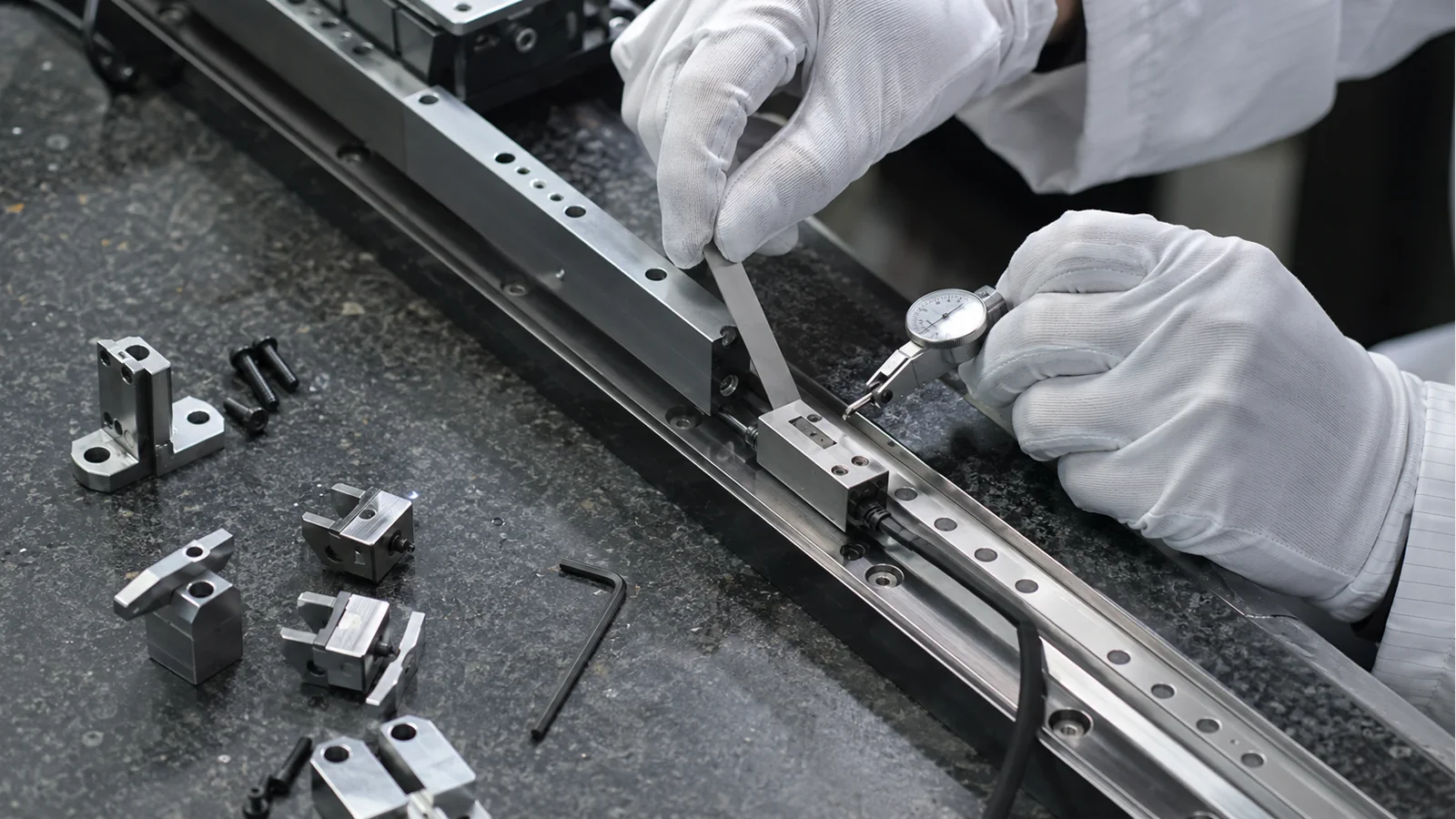 Technician aligning a linear encoder readhead and scale on a precision motion stage