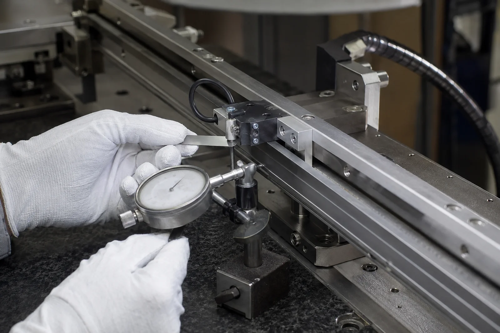 Close-up of a linear encoder readhead gap fixture and scale on a precision stage
